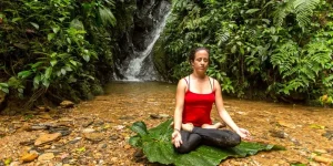 Tourist meditating in the middle of the rainforest